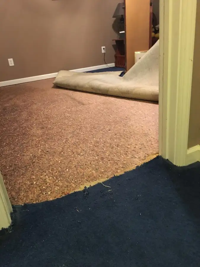 Carpet pad removal revealing water damage during Water Mitigation Services in Menominee